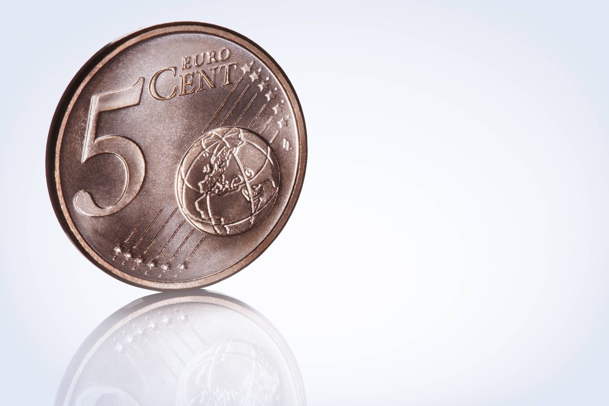 Eine 5-Cent-MÃ¼nze steht senkrecht auf dem Boden.