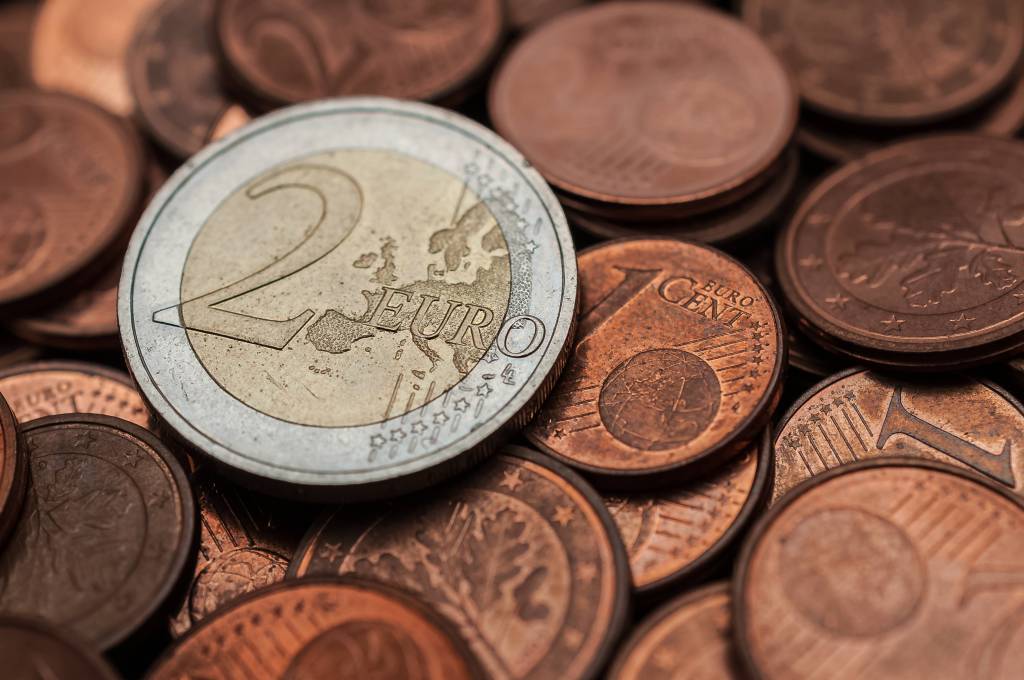 Eine 2-Euro-Münze liegt auf einem Haufen mit Ein-Cent-Münzen.