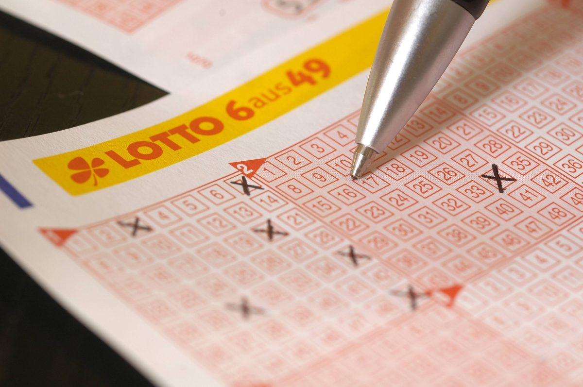 Ein Spieler kreuzt Zahlenfelder auf einem Lotto-Tippschein der Variante 
