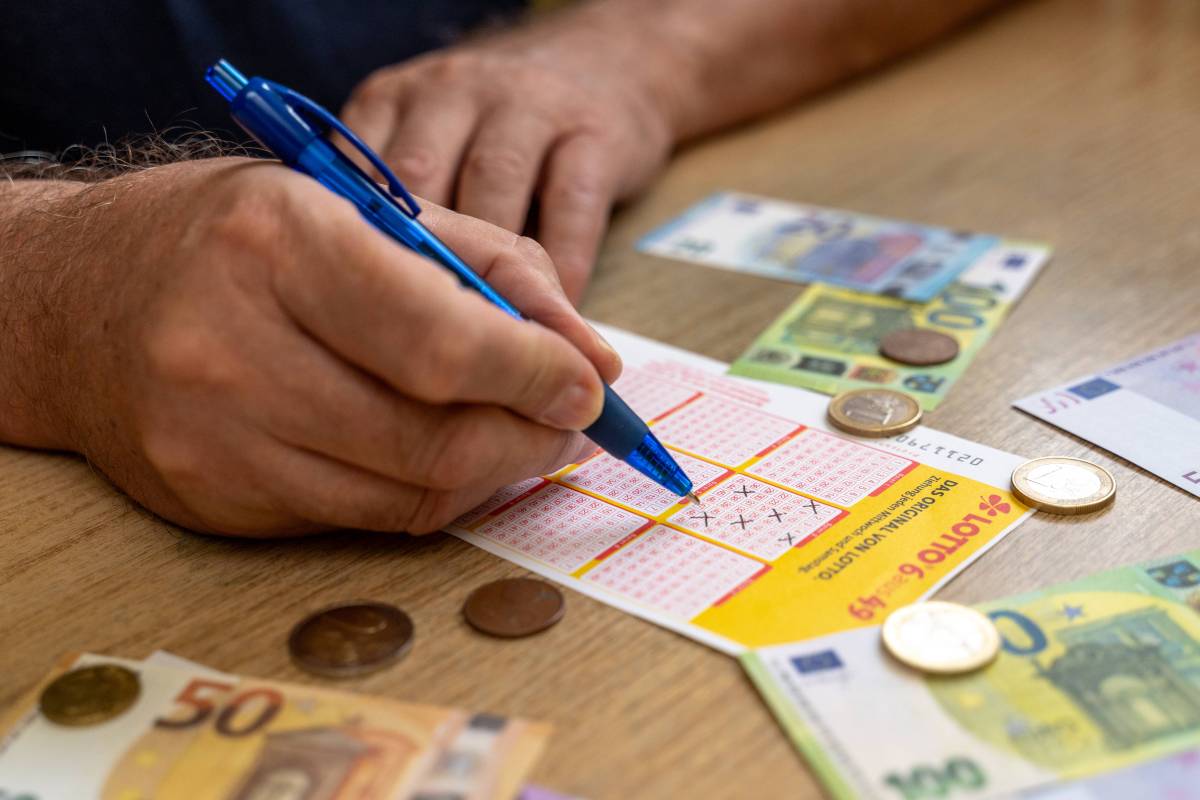 Ein Mann füllt einen Lotto-Schein von Hand aus.