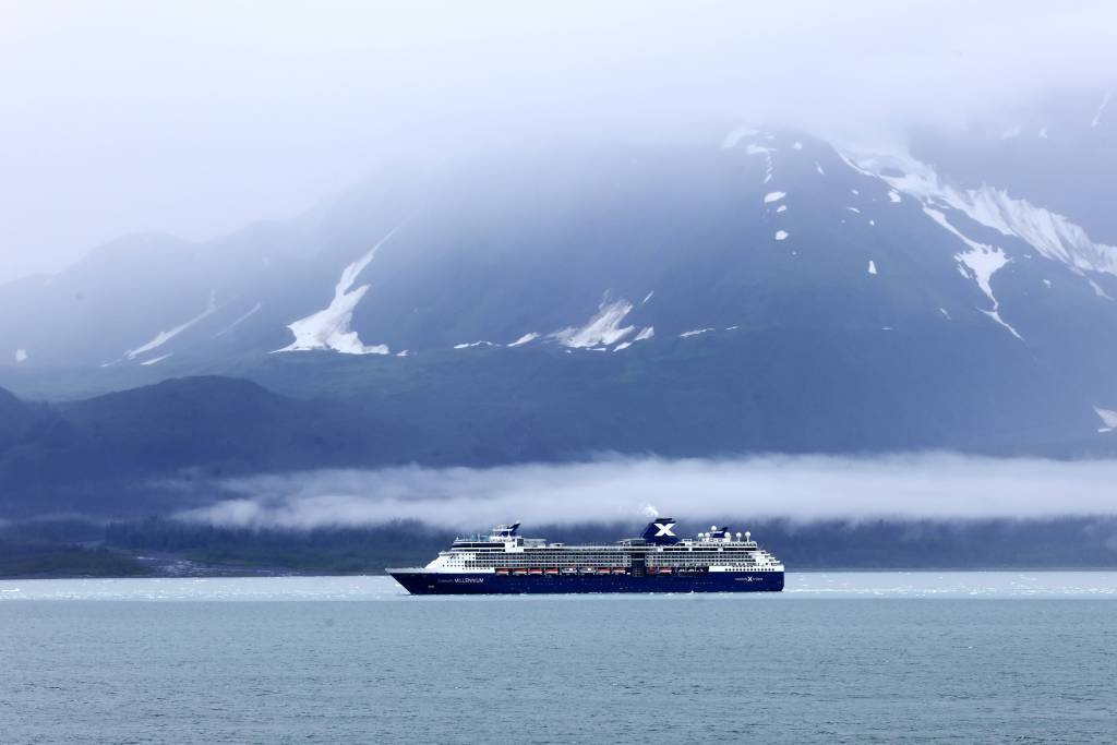 Ein Kreuzfahrtschiff vor schneebedeckten Bergen.