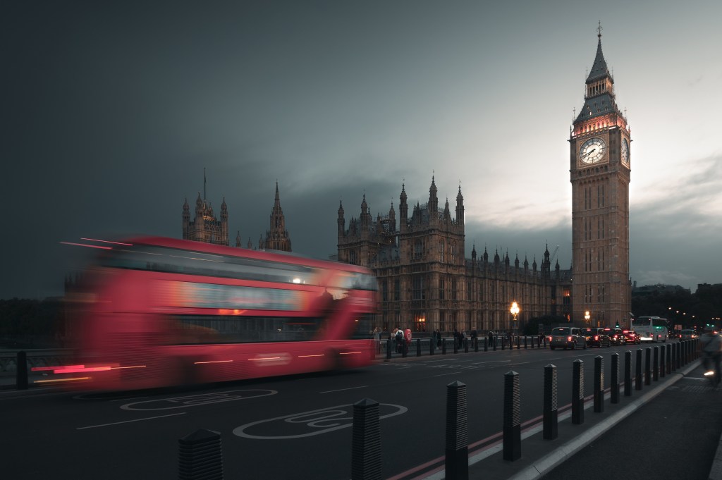 Ein Bus fährt an den Houses of Parliament und Big Ben auf der Westminster Bridge vorbei, während dichter Nebel die Hauptstadt bedeckt. London, Vereinigtes Königreich.