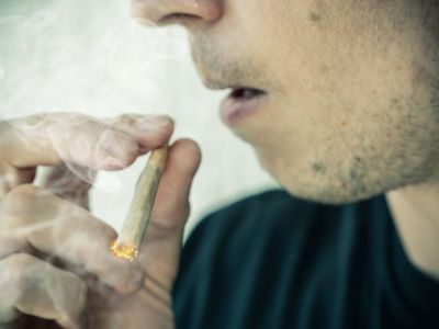 Ein Mann konsumiert einen Cannabis-Joint (Symbolbild).