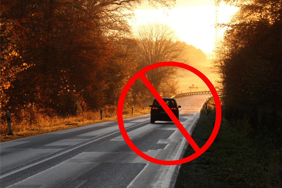 Ein Auto fährt auf einer Landstraße.