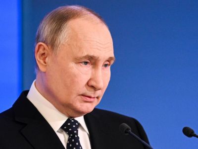 Wladimir Putin steht an einem Rednerpult.