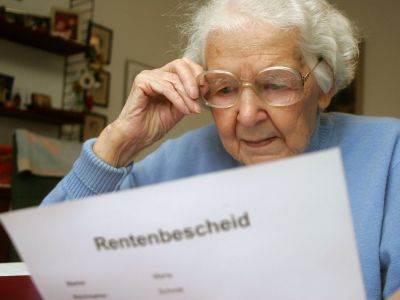 Eine ältere Frau bemustert ihren Rentenbescheid.