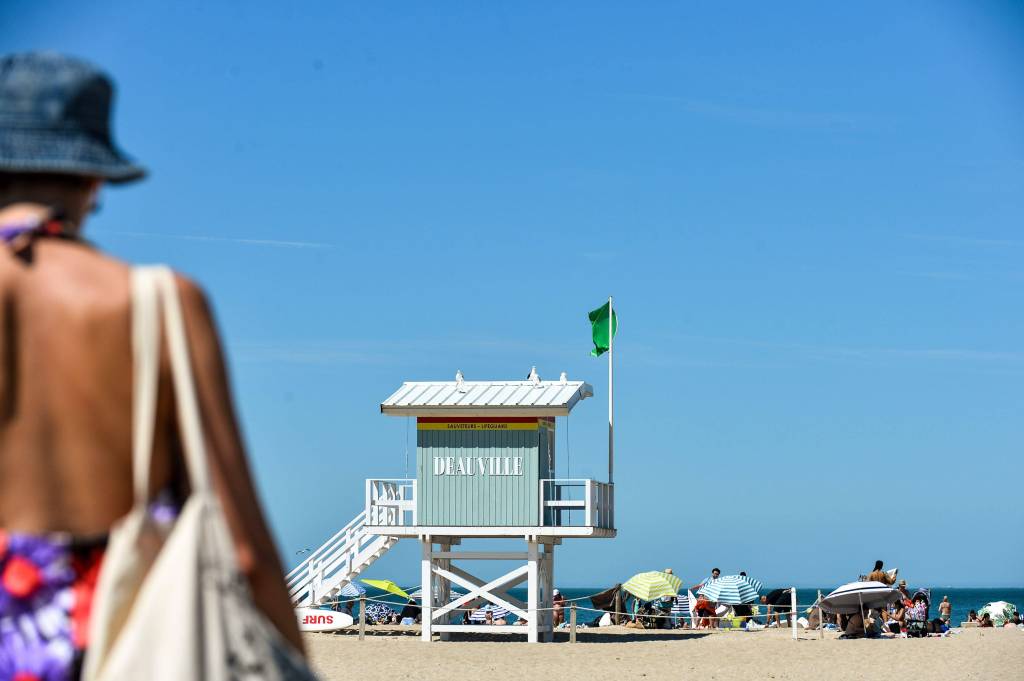 Frau vor Strand mit Wachturm