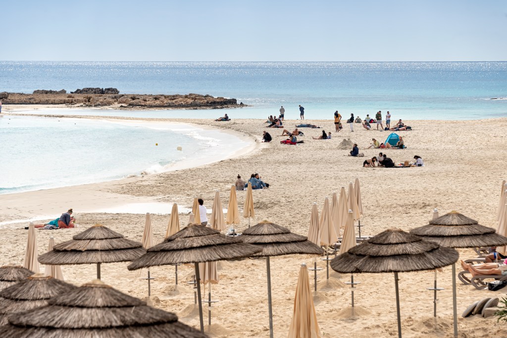 Strand mir Sonnenschirmen und Touristen