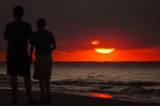 Zwei Männer am Strand bei Sonnenuntergang.