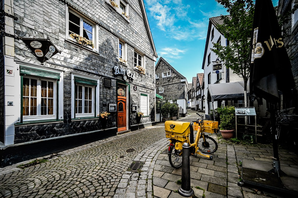Ein Blick in eine Gasse des historischen Stadtviertel Kettwig in Essen mit Fachwerkhäusern und Kopfsteinpflaster.