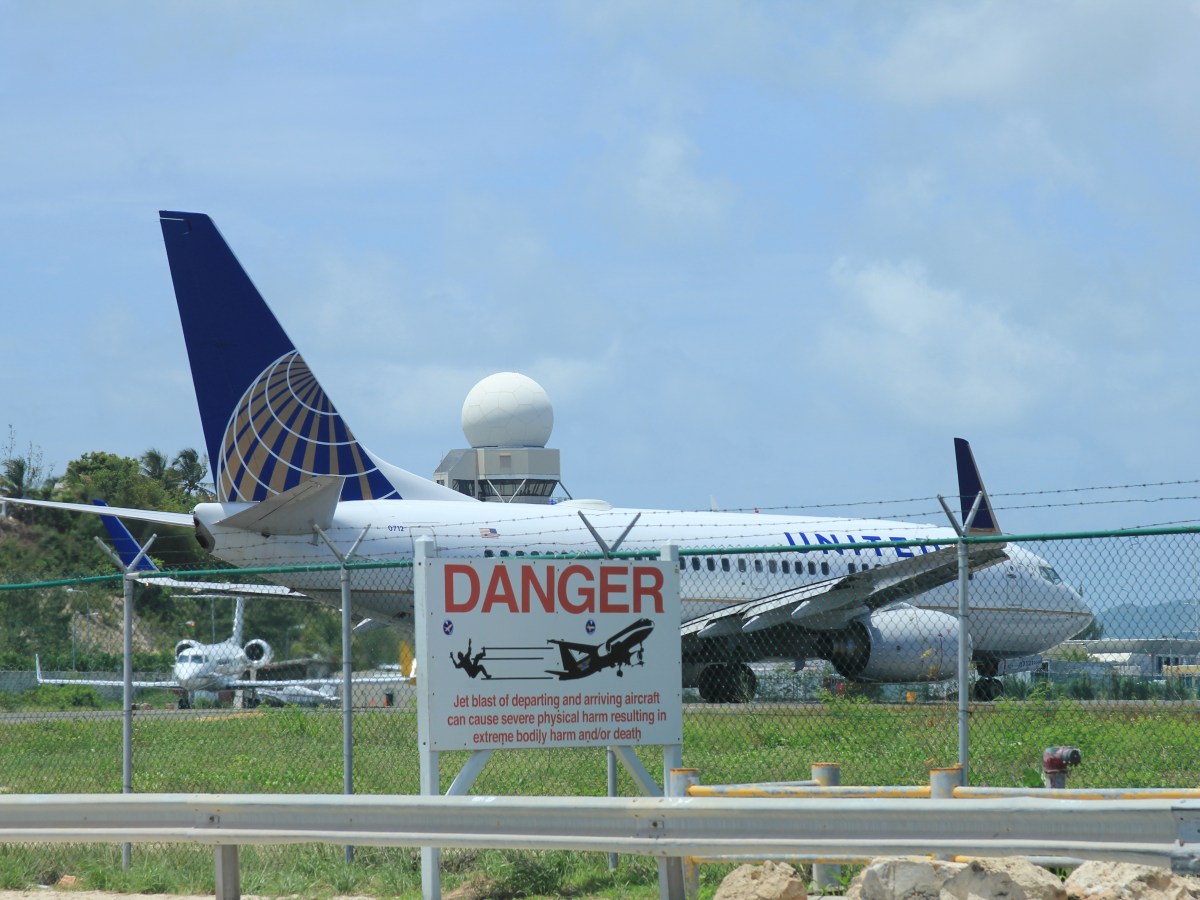 Flugzeug hinter Zaun mit Danger-Zeichen