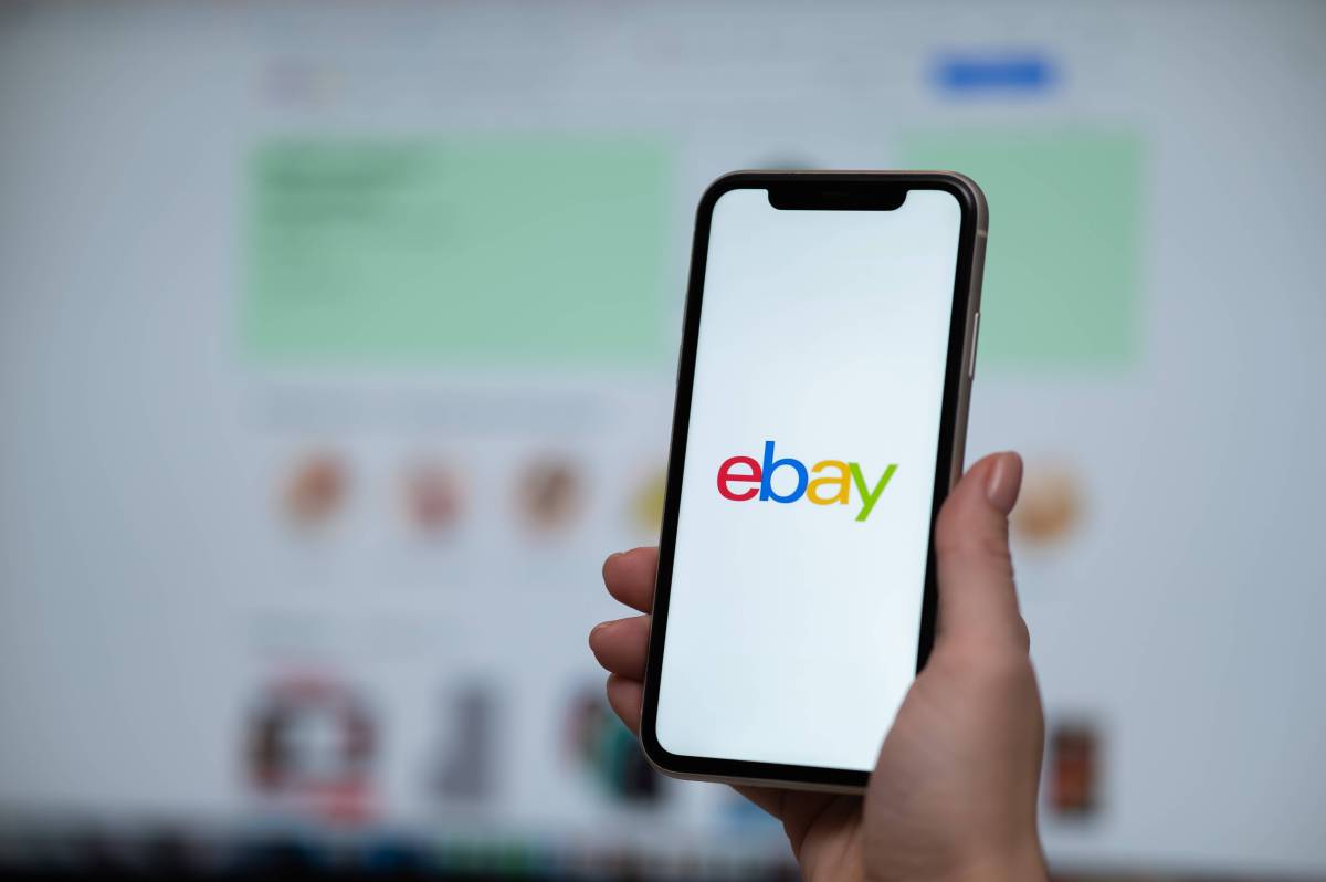 Handy mit Ebay Logo vor Ebay Website