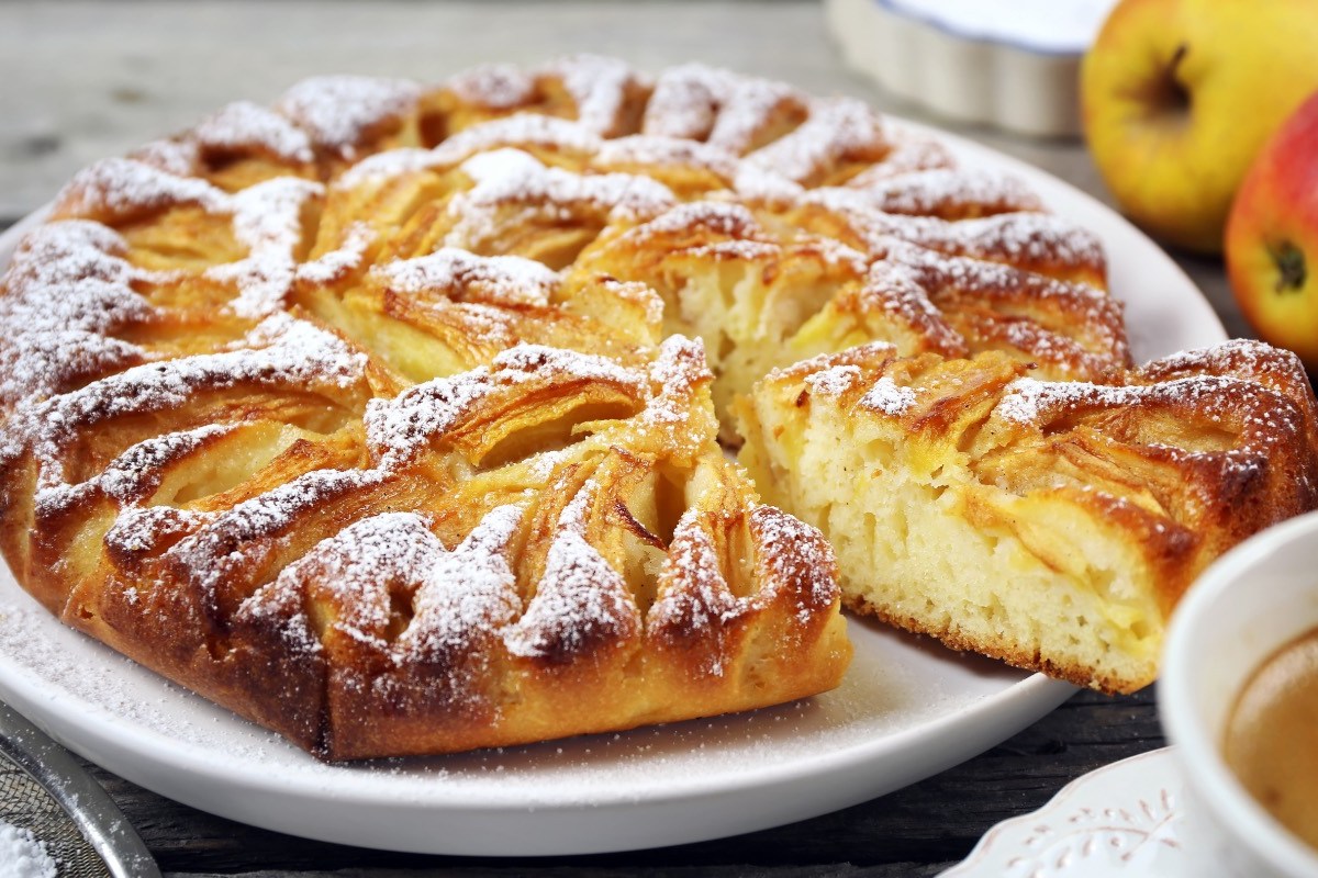 Ein Elsässer Apfelkuchen mit Puderzucker auf einem Teller.