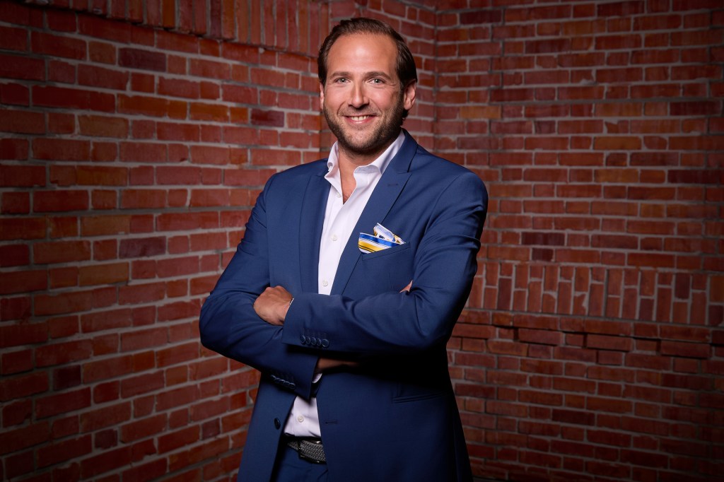 Julian Schmitz Avila in blauem Anzug mit weißem Hemd
